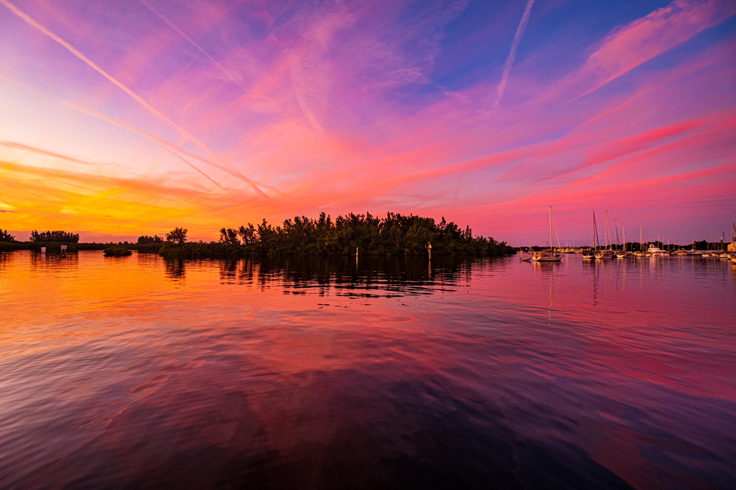 The colorful sunset sky reflected in the sea near the port